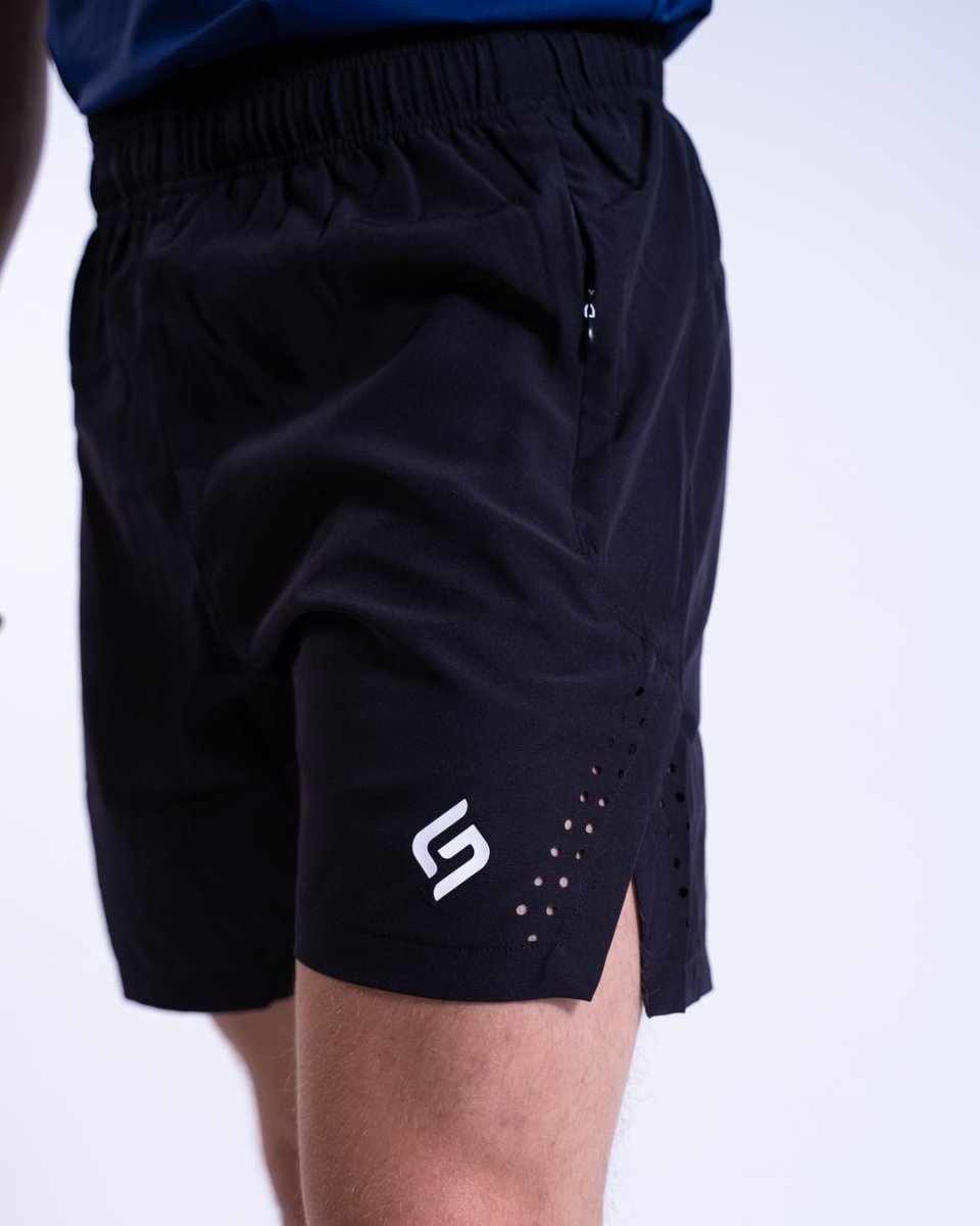 Side profile of black men’s shorts with logo and breathable ventilation for high-performance activities.