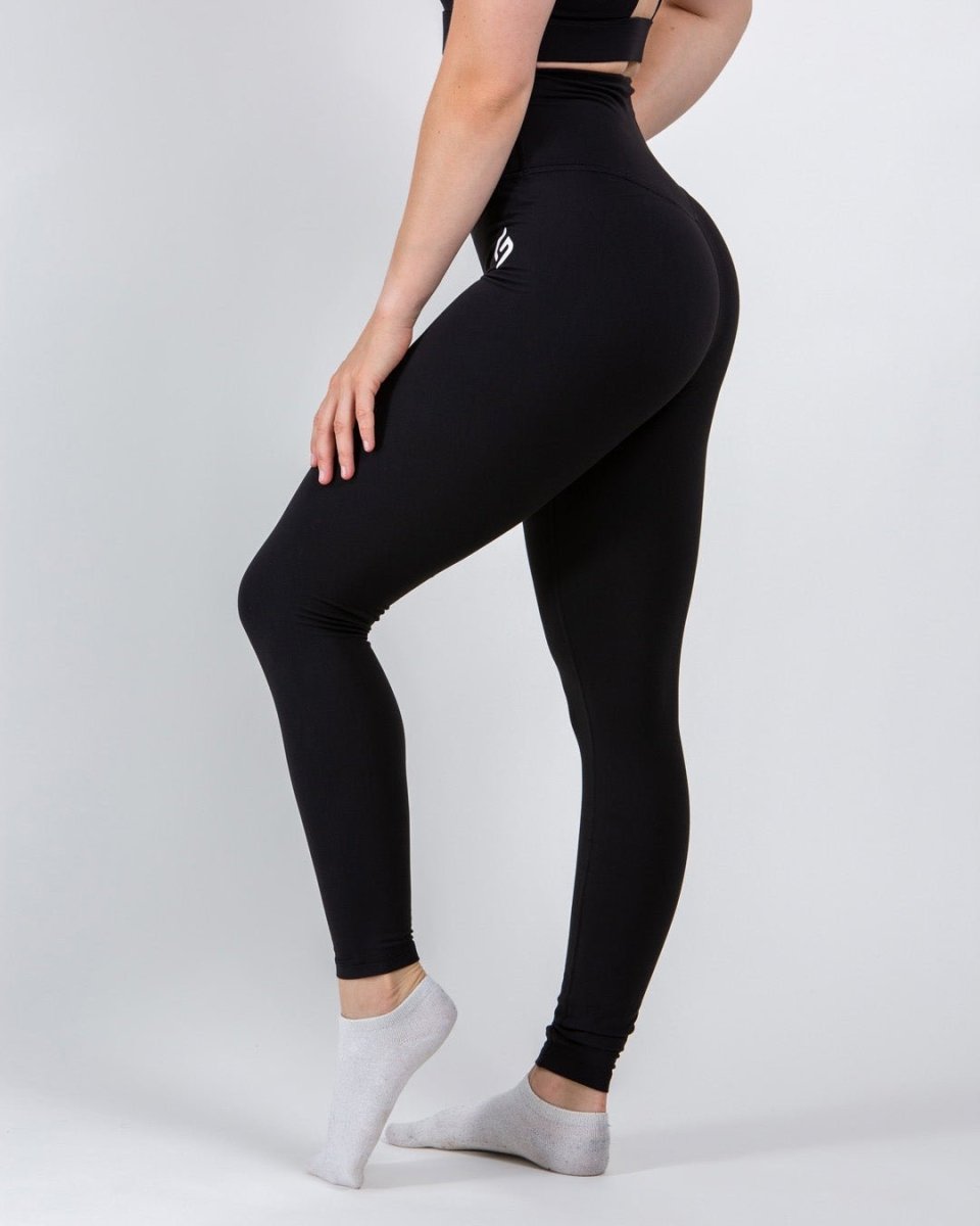 Side view of black high-waist core tights for women, showcasing the comfortable and flexible fit.